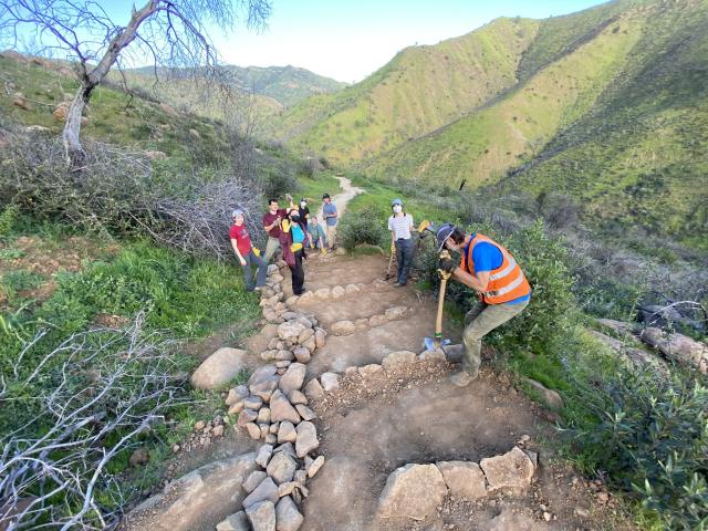 A crew builds trail stairs in a deep canyon 