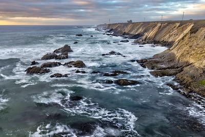 Waves lap against a coastal bluff.