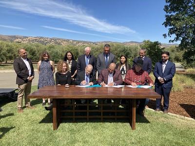 People around a table signing a document