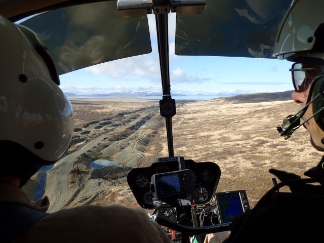 Photo from inside the cockpit of a helicopter overflying dry riverbed
