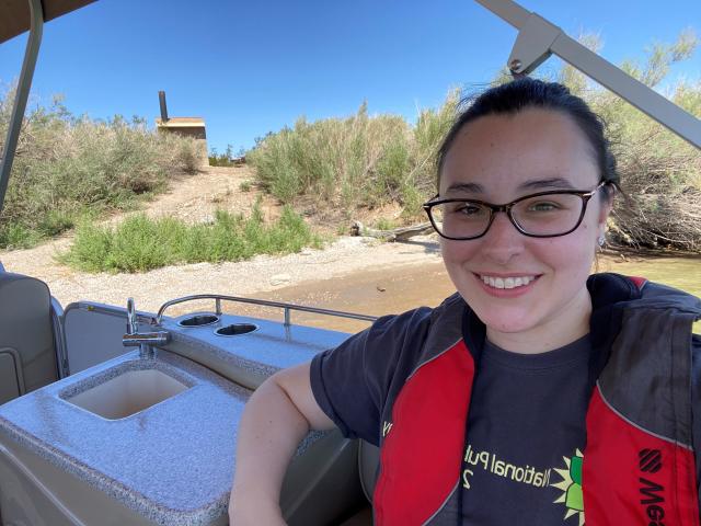 Kaitlin in the foreground with campsite behind her from boat.