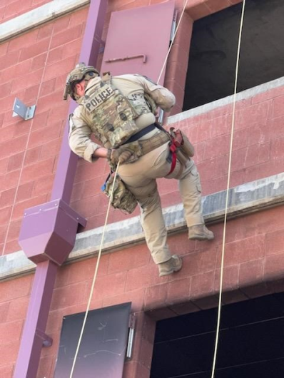 Brian Pucket repelling down a building wall in rescue gear