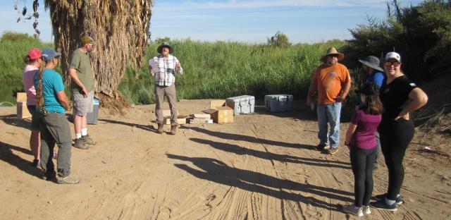 Volunteers stand in circle to receive briefing from BLM employee.