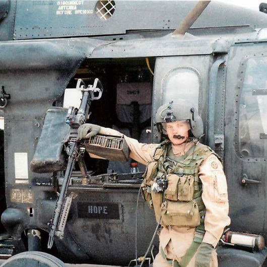 Nic in front of Blackhawk helicopter gunner seat