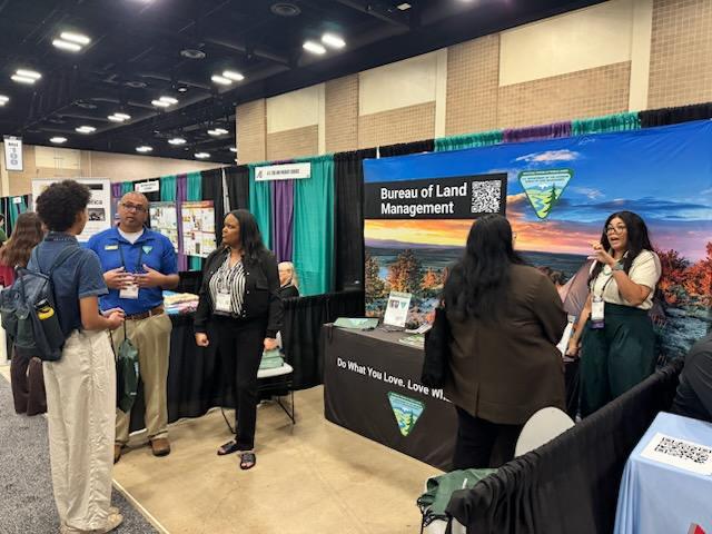 Kenneth Barber, BLM Wyoming; Christal Smaw, BLM Alaska; and Brooke Wheeler, BLM Arizona, speaking to students at the AISES Career Booth.