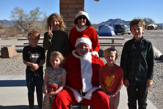 Mr. and Mrs. Clause pose with children for Christmas photo.