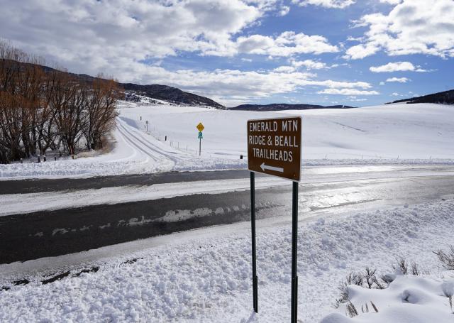 roadside sign along roads covered in snow