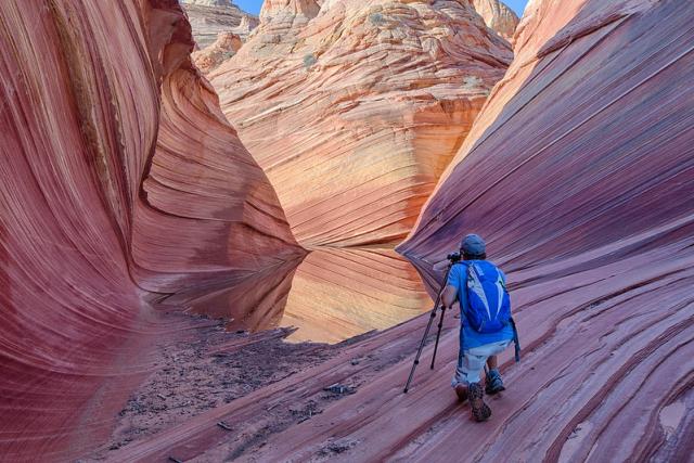 A man takes photos inside of a canyon at Vermilion Cliffs National Monument