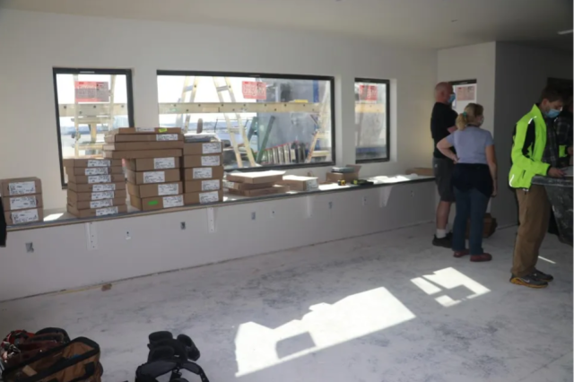 People stand in a room under construction