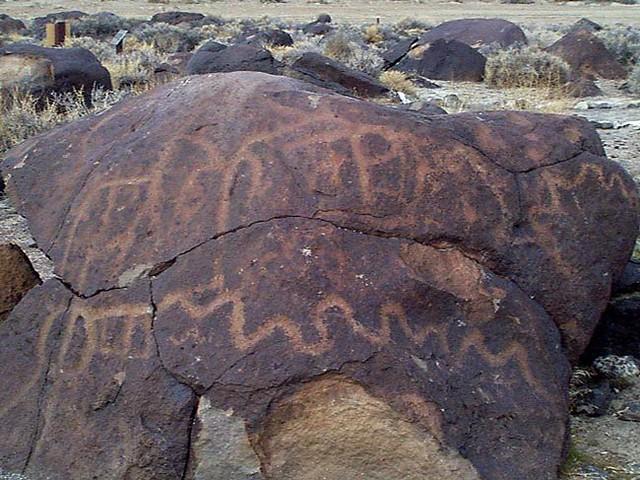 Primitive rock art featured on a dark boulder