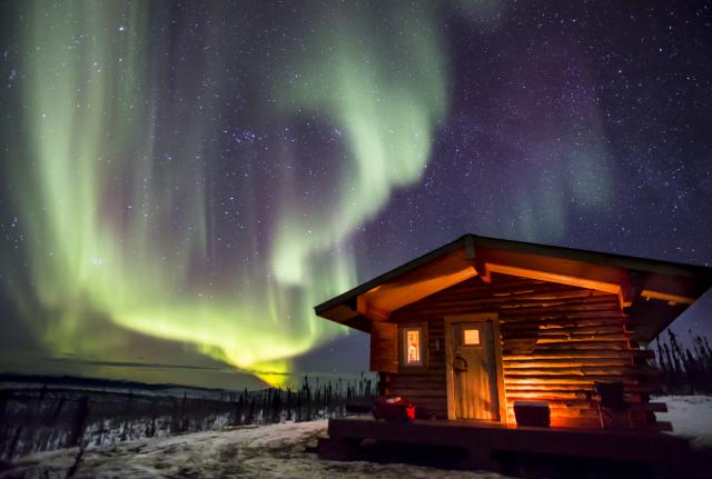 the Northern Lights over a cabin