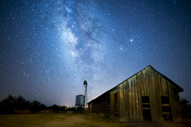 the Milky Way shines over a historic barn