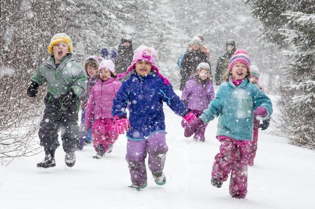 A group of children run in the snow