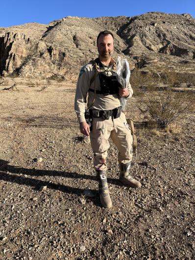 Law enforcement officer stands in full uniform 