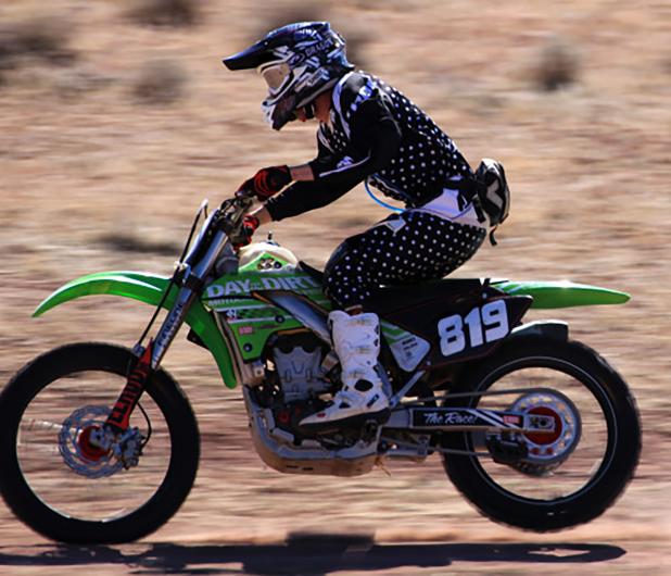 An off-road race participant drives a motorcycle in the desert