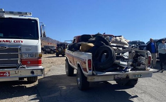 Pick-up truck with tires and other debris arriving at dumping station.