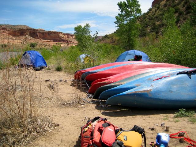 Boats and equipment stacked alongside the Colorado River