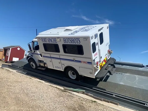 A large vehicle labeled Fort Apache Hotshots sideways on a steeply inclined ramp