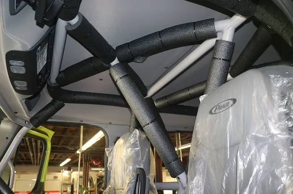 A metal frame with foam padding on the inside roof of a vehicle