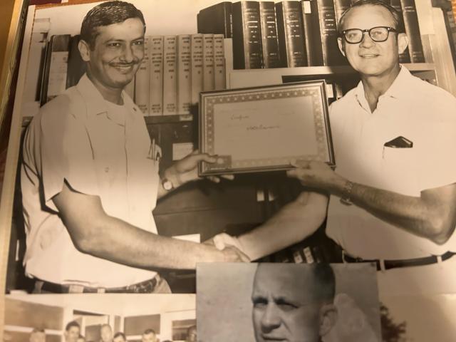 a black and white photo shows a man receiving an award