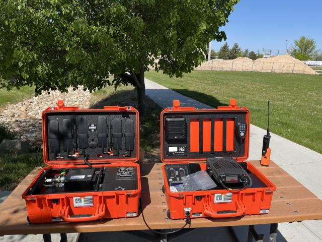Two orange pelican cases open displaying radio parts