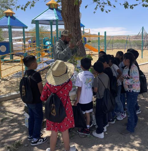 Kids around a table with a BLM Range employee