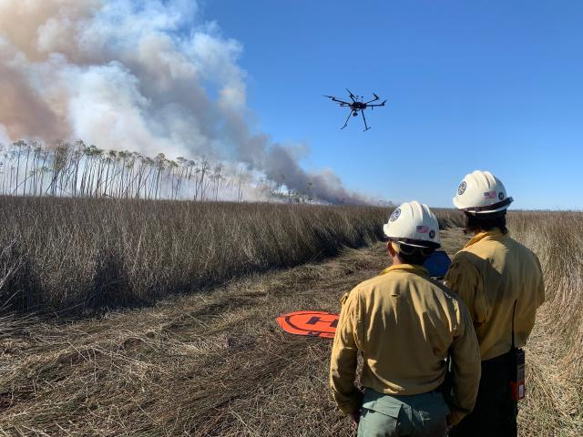 Fire crew members pilot drone to survey a blaze.