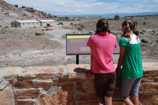 Kids looking at interpretive sign overlooking Cleveland Lloyd Dinosaur Quarry