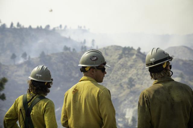 Three wildland firefighters receiving orders.