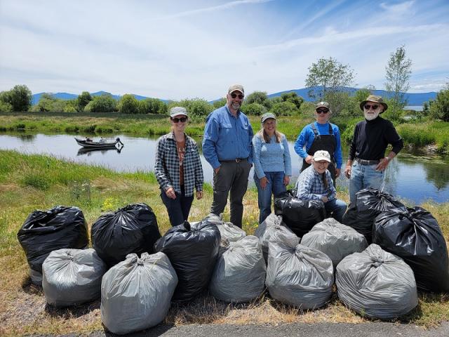 group of volunteers standing near bagged garbage at Wood River Wetlands