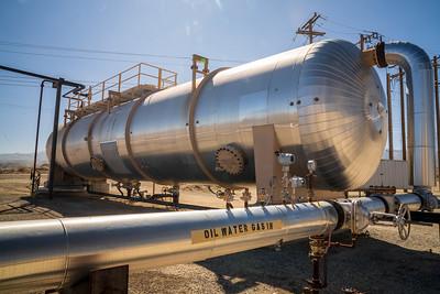 A large silver tank with pipes coming in and out of it. 