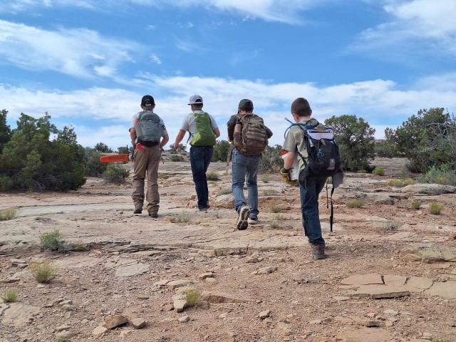 Troop 8 scouts hiking in a line, carrying various equipment