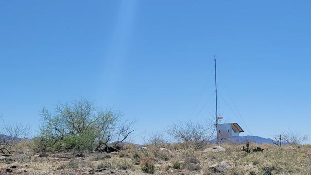 an antenna stands in a desert landscape