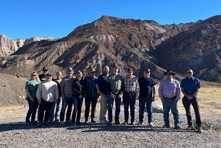 A line of DAC members stands in front of rocky, white desert hills.