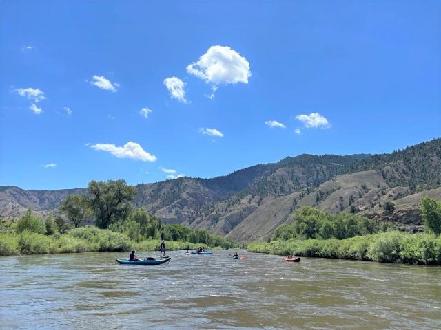 People on kayaks and paddle boards floating along the scenic Colorado River