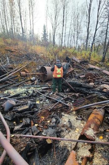 Figure 2: Transburg inspects the fire damage at a historic stamp mill in the McGrath area. Photo by Tony Gallagher (BLM).
