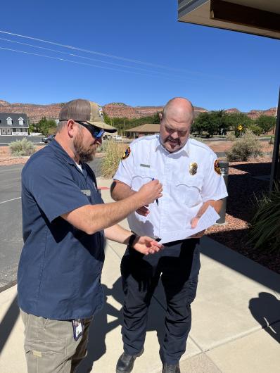BLM Robert Lopez hands pen to Kanab Fire Chief Brett Pierson to sign over the engine