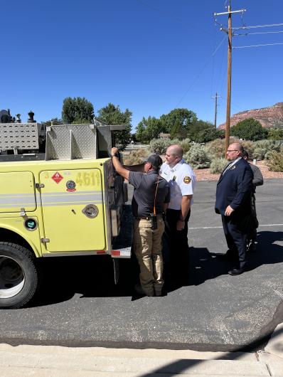 BLM employees Mike Espoinoza and James Swap inspect the engine with Kanab Fire Chief Brett Perison and President of the Kanab Fire and EMS Association Spencer Mosdell 