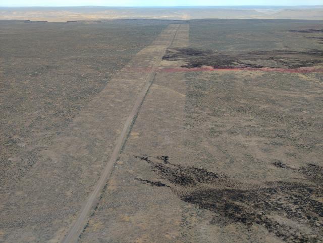 Landscape from above that shows evidence of fire stopping at a road