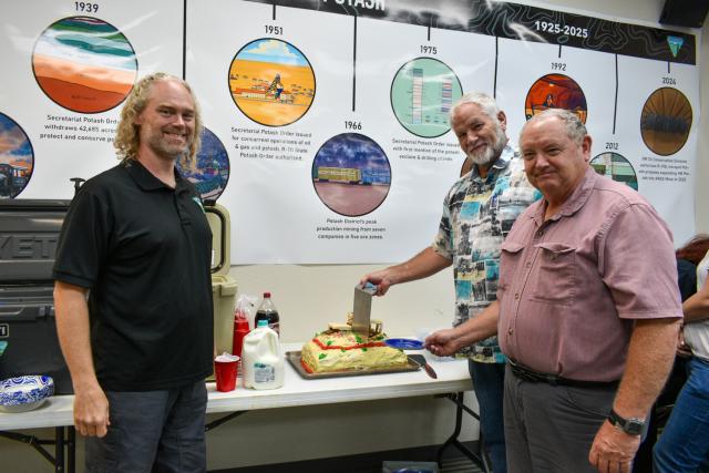 From left, Tom Evans, Jim Rutley and Paul Murphy pose next to a cake that Murphy made for the event.