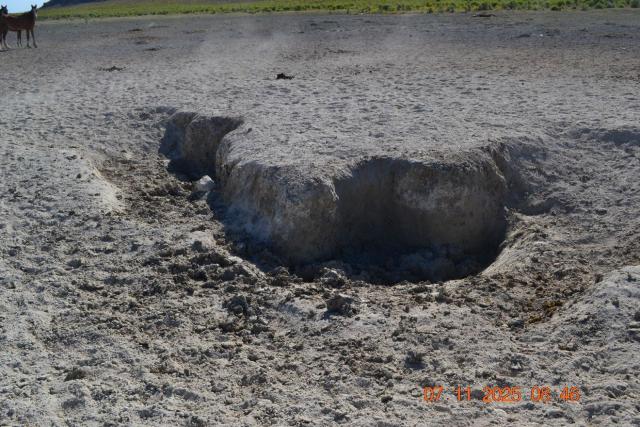 A hole in the dusty dirt. 