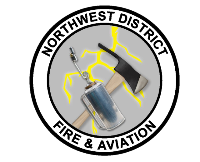 Northwest District Fire and Aviation emblem with a pulaski and a drip torch and lightning over a gray packground