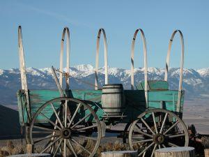 Covered wagon without canvas, with snowy mountains behind