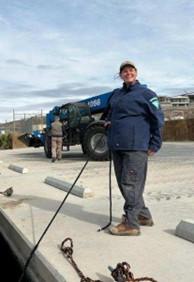 BLM employee secures rope to dock that is attached to an out of frame boat.
