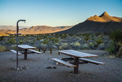 Two picnic tables in a desert campground