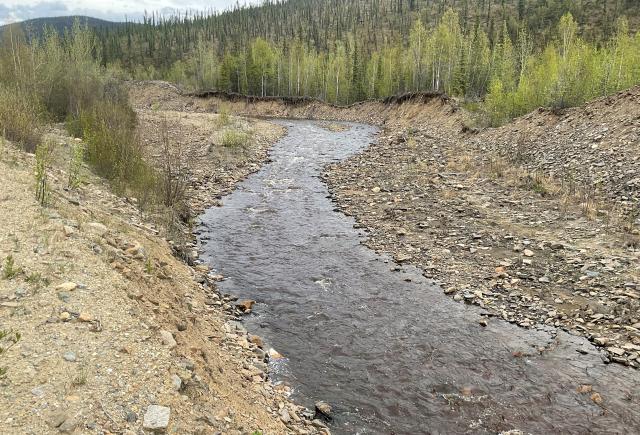An interior Alaska creek meanders through remnants of a mining operation.