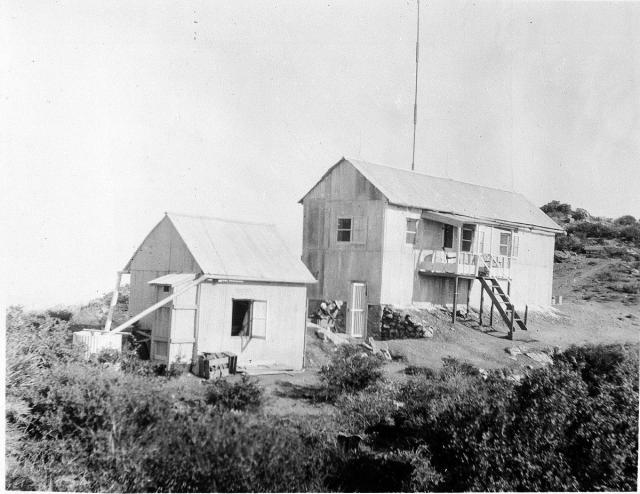 a historic photo of two buildings with peaked roofs