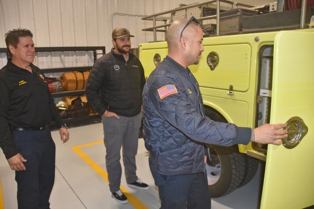 Several men look at a yellow Type 6 fire engine.