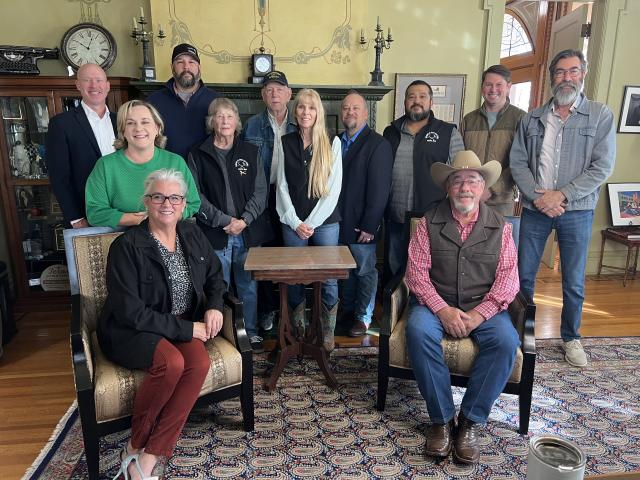 Group photo of 12 people posing in a room.