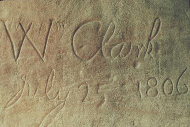 Close-up of sandstone with the inscription 'Wm Clark July 25 1806' carved in cursive handwriting.
